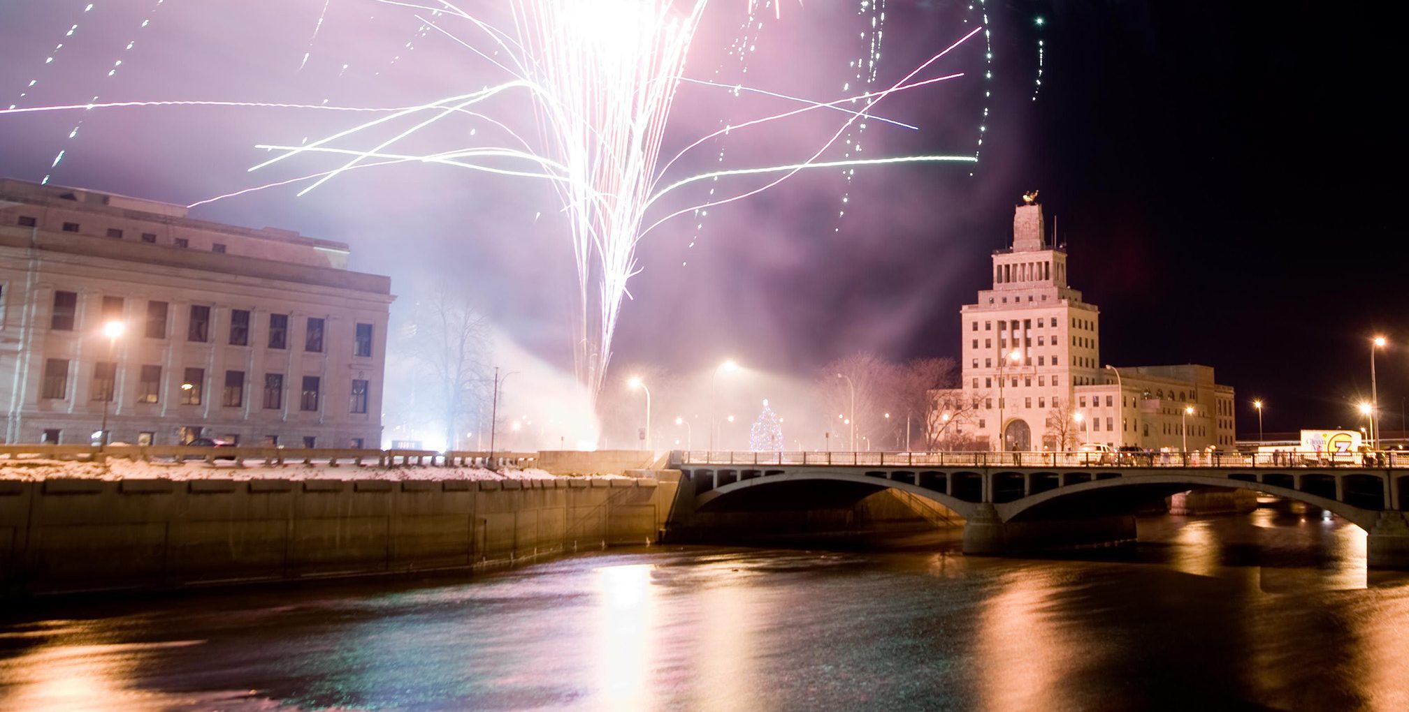 Fireworks and the city skyline over the river in Cedar Rapids
