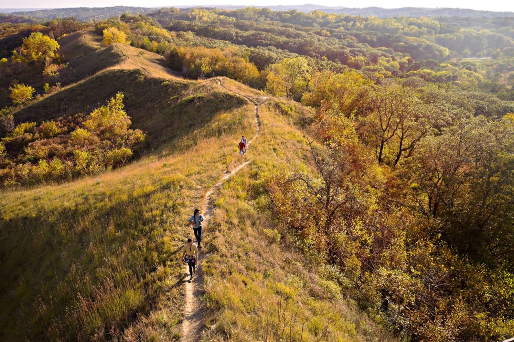 Hikers walking on an outdoor trail in the hills.