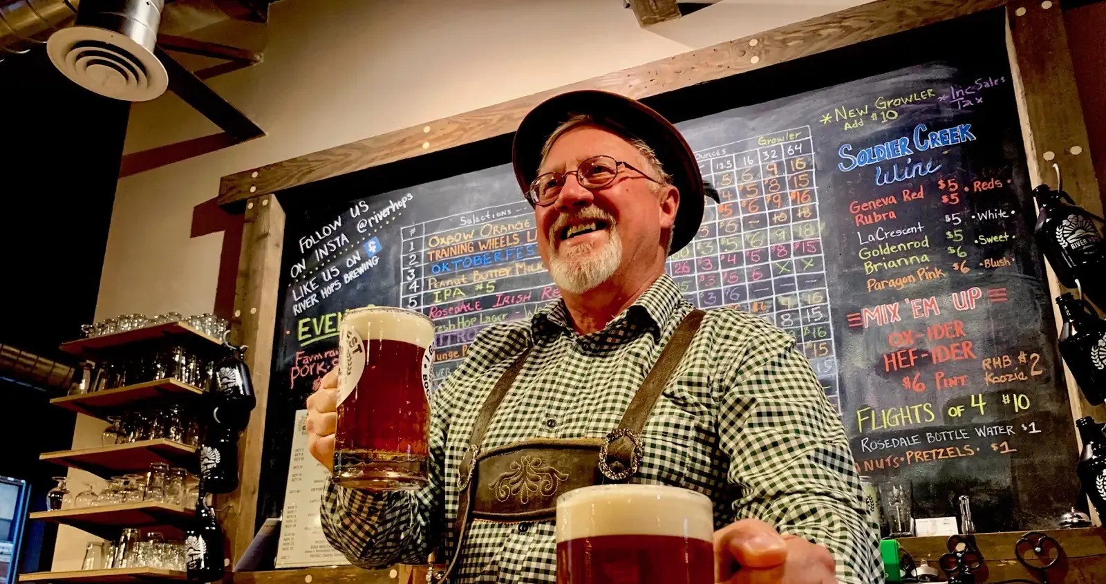 Older man with white beard serving pints of beer.