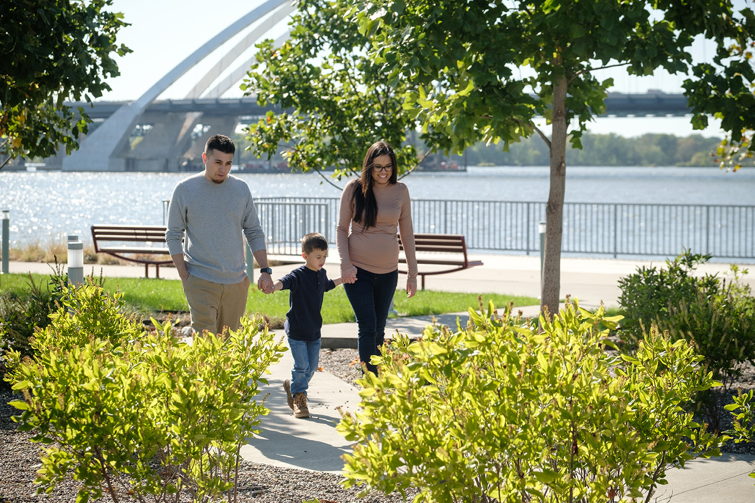 A family walks in a park near a river
