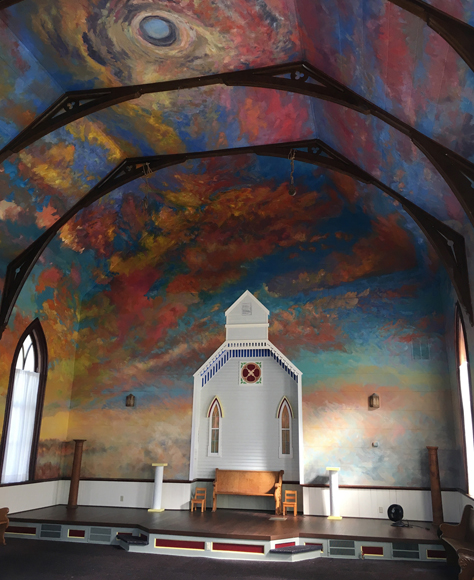 Interior view of Art Church with it's painted mural ceiling to depict the sky at twilight.
