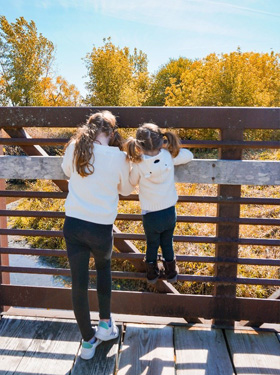 Two young girls looking at the fall colors from a lookout point.