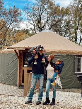 Family standing outside of a tent.