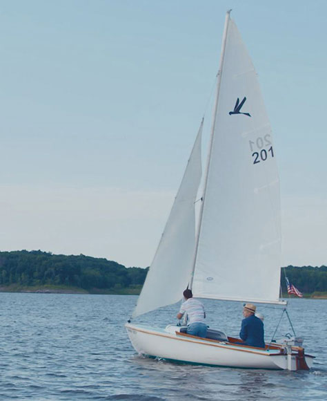 Dr. Michael Abramoff sailing on his boat on a lake.