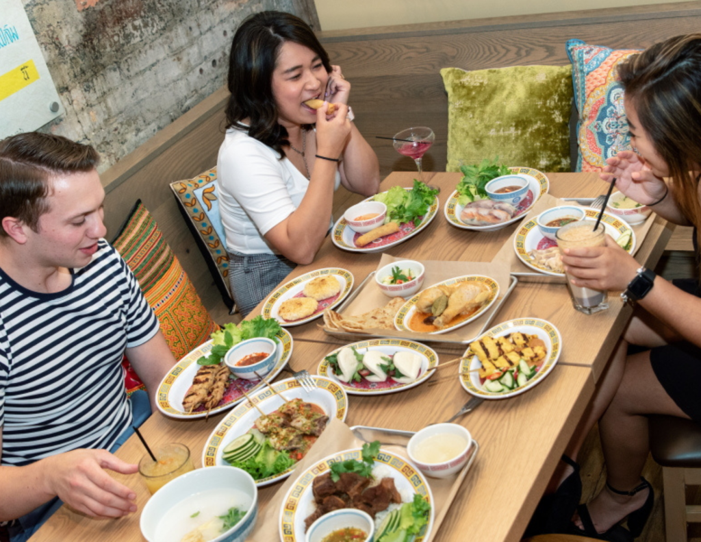 Three people eating southeast asian food