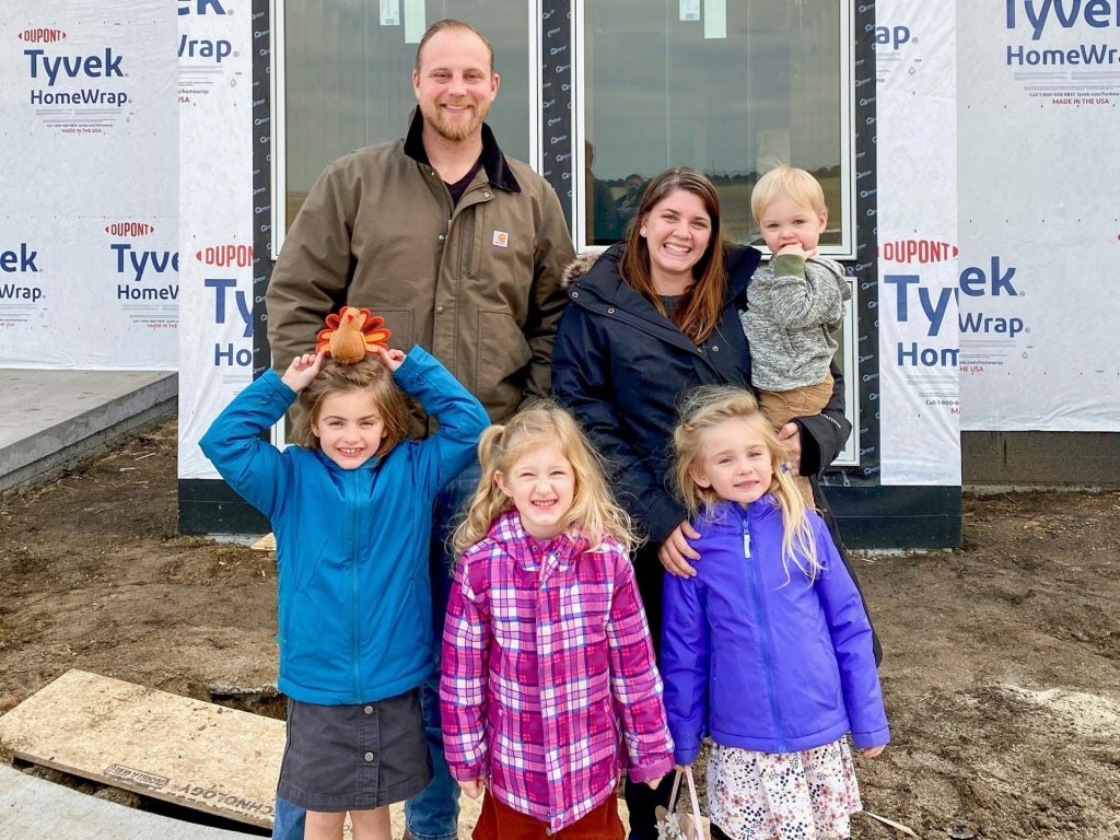 Stiles family standing in front of their new construction home