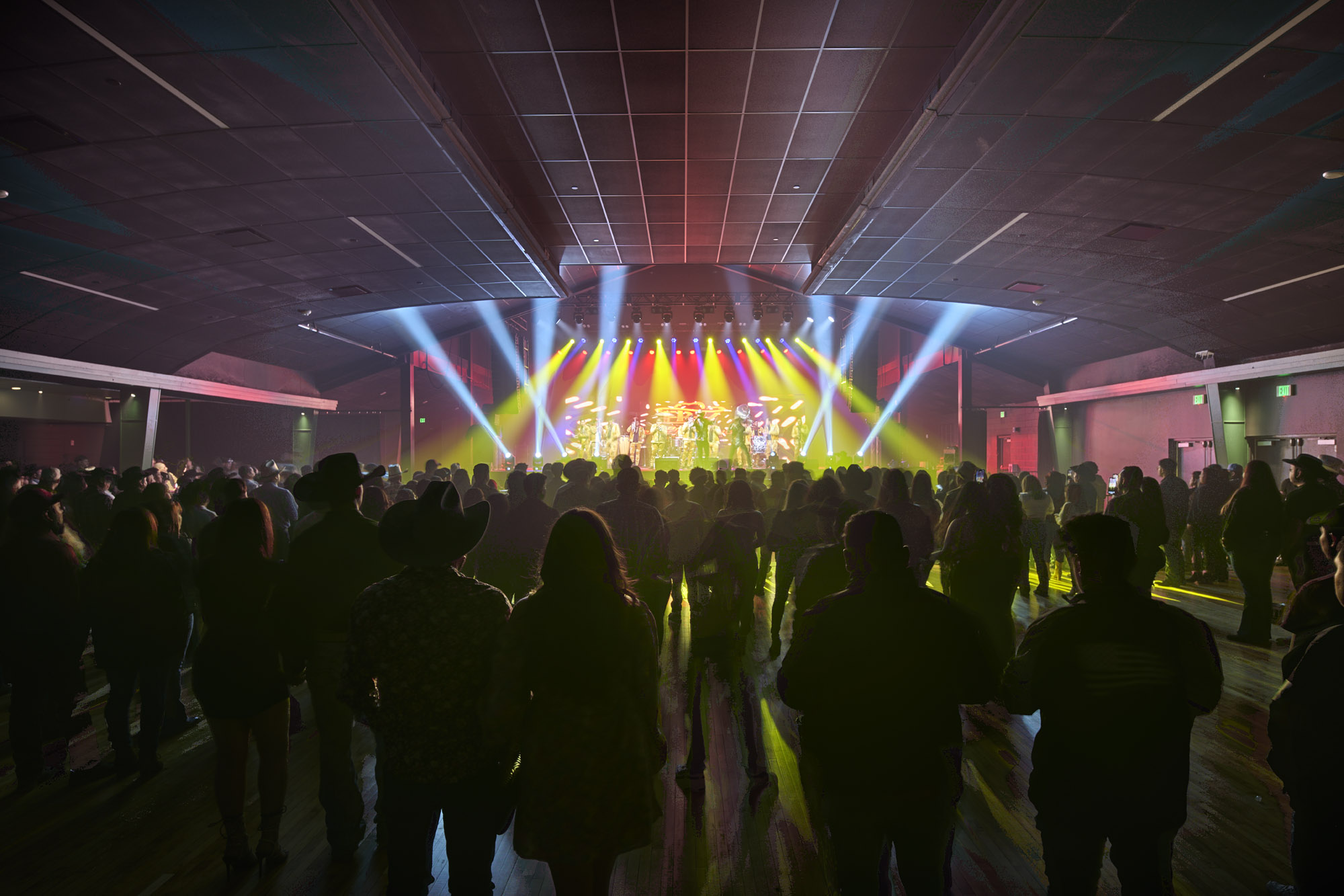 Crowd of people facing the stage with lights at a live music show at Val Air Ballroom