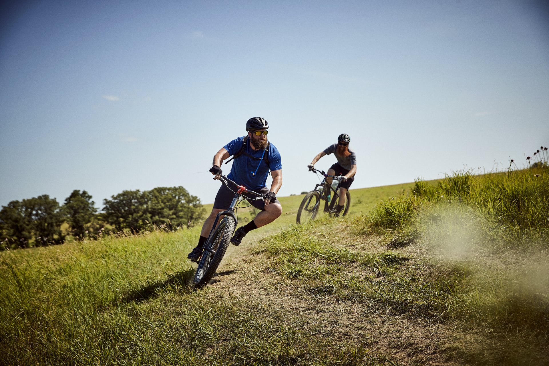 two mountain bikers turning down a dirt path