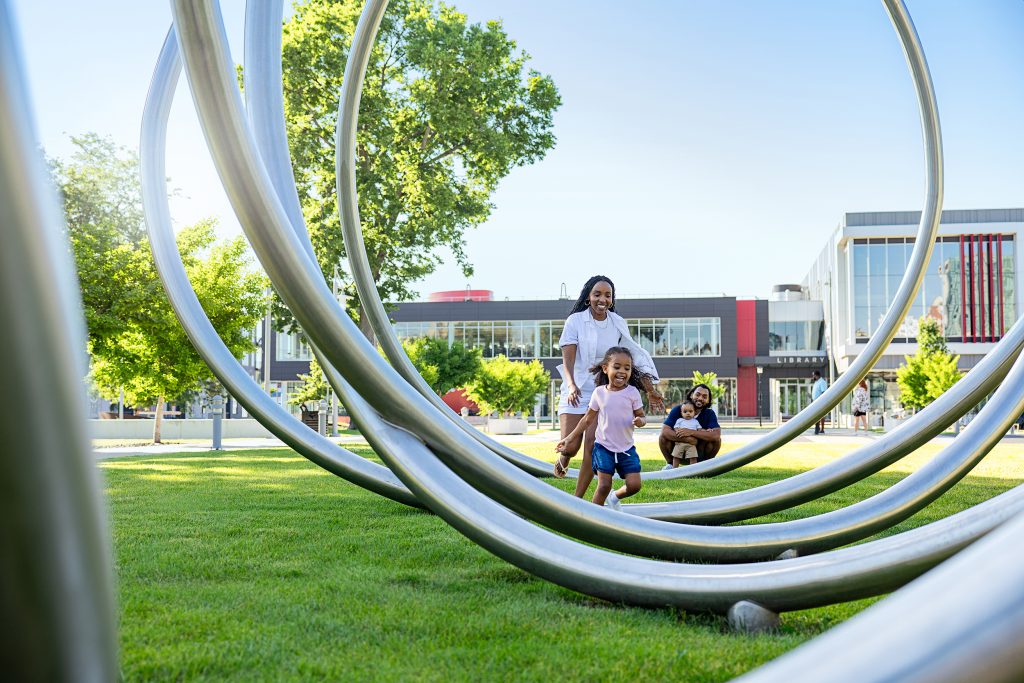 A family of four playing in a sculpture park