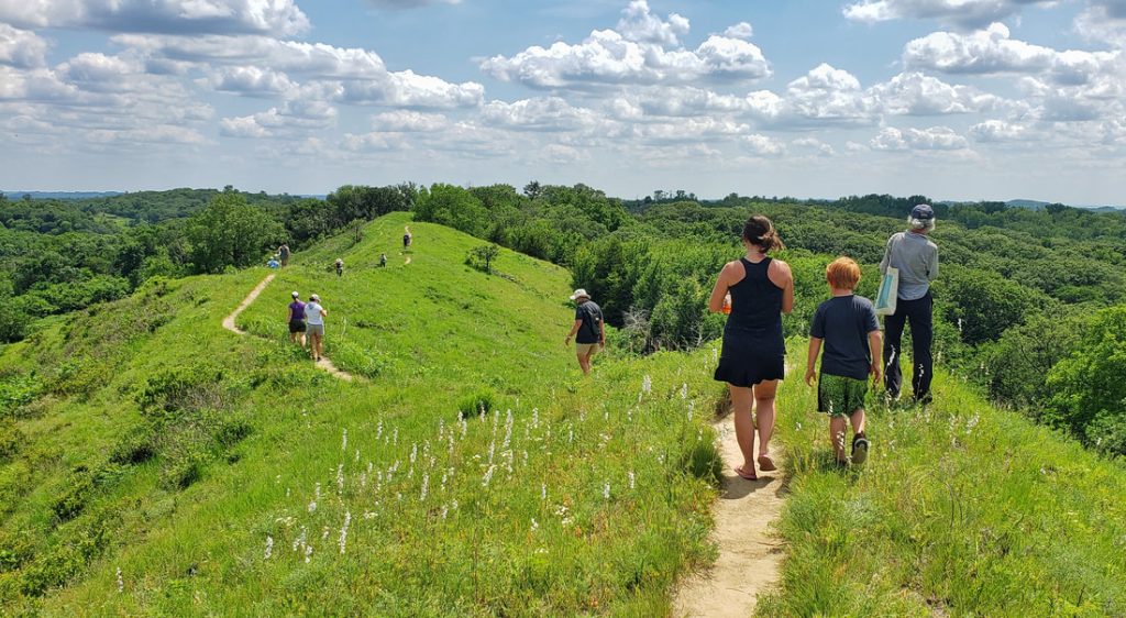 Hikers set off on a narrow path through Iowa's Loess Hills.