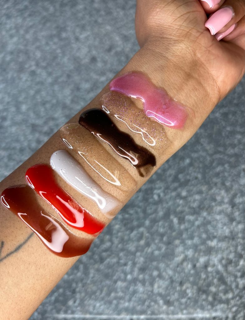 Color swatches of lip gloss on the inside of a person's arm