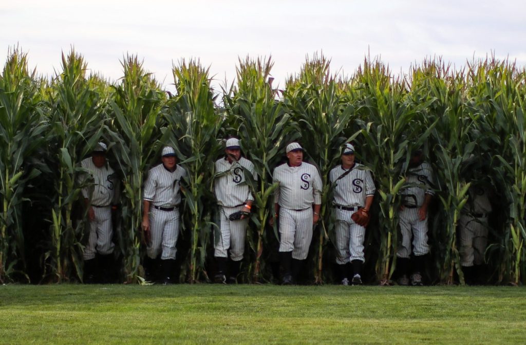 baseball players walking out of cornfield