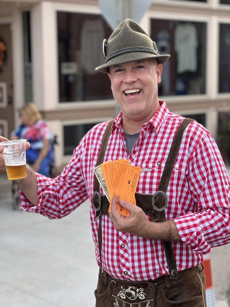 man wearing German outfit and holding a glass of beer