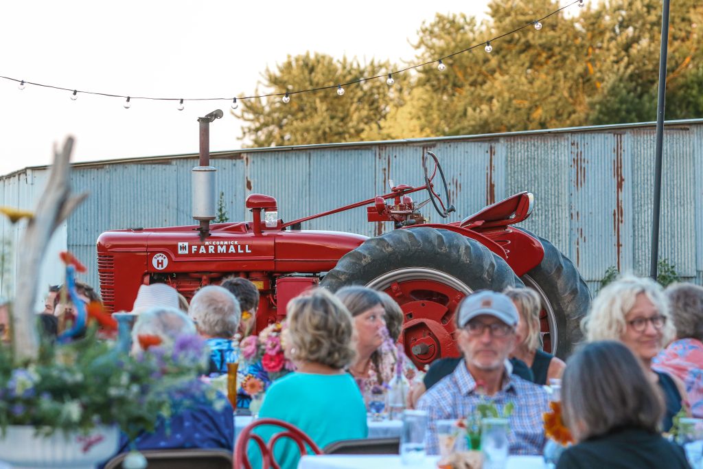 outdoor diners in front of Farmall tractor