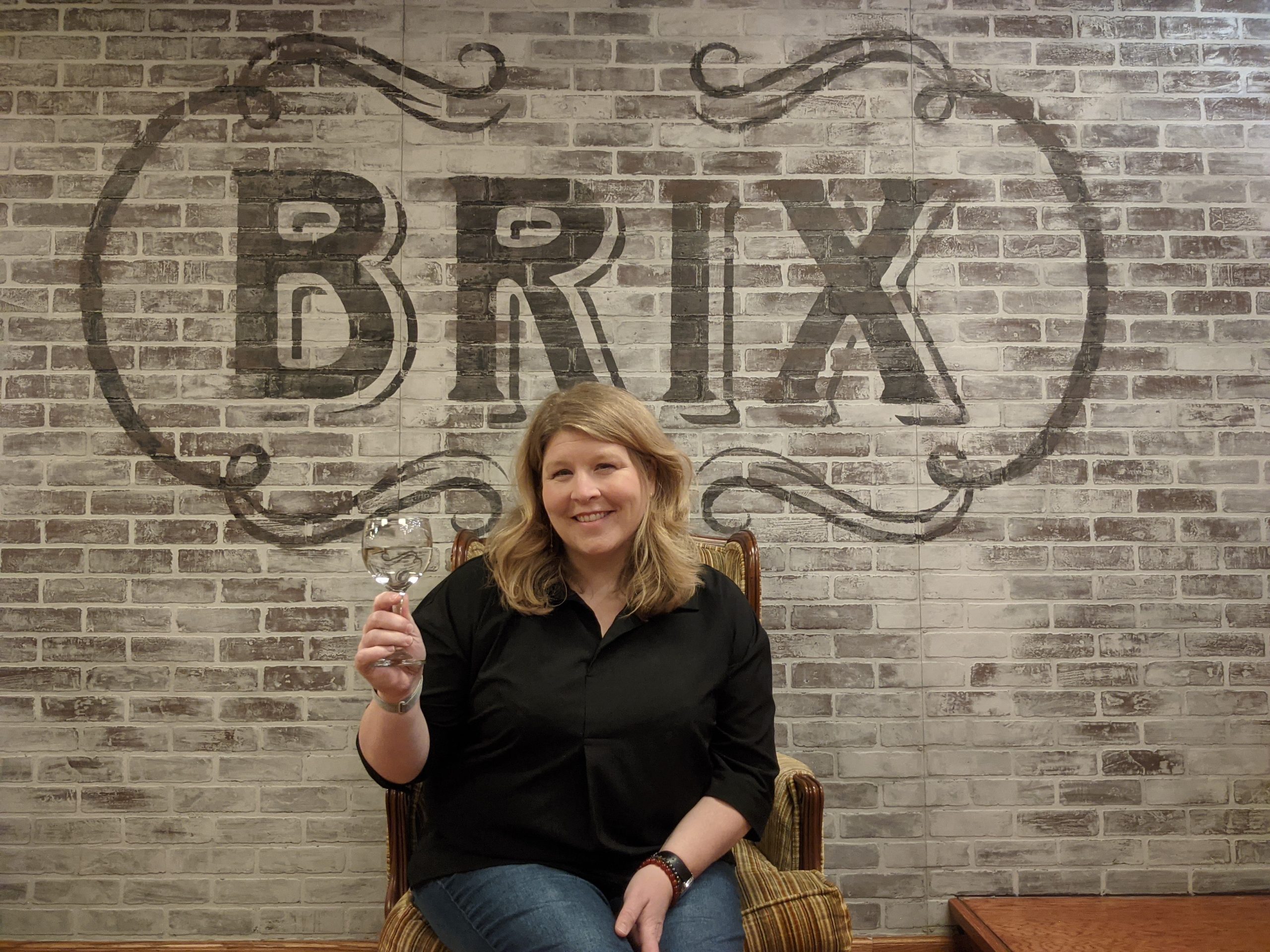 Melissa Evans holds an empty wine glass in front of her new business.