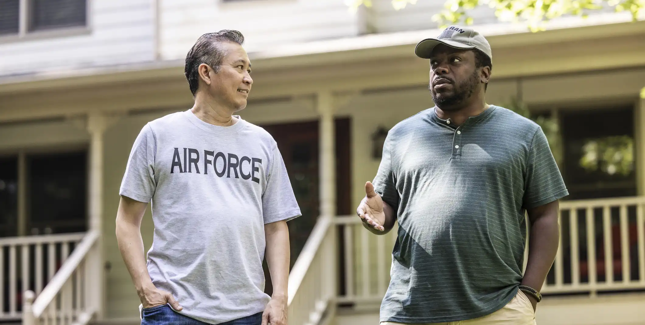 Two veterans chat on a lawn
