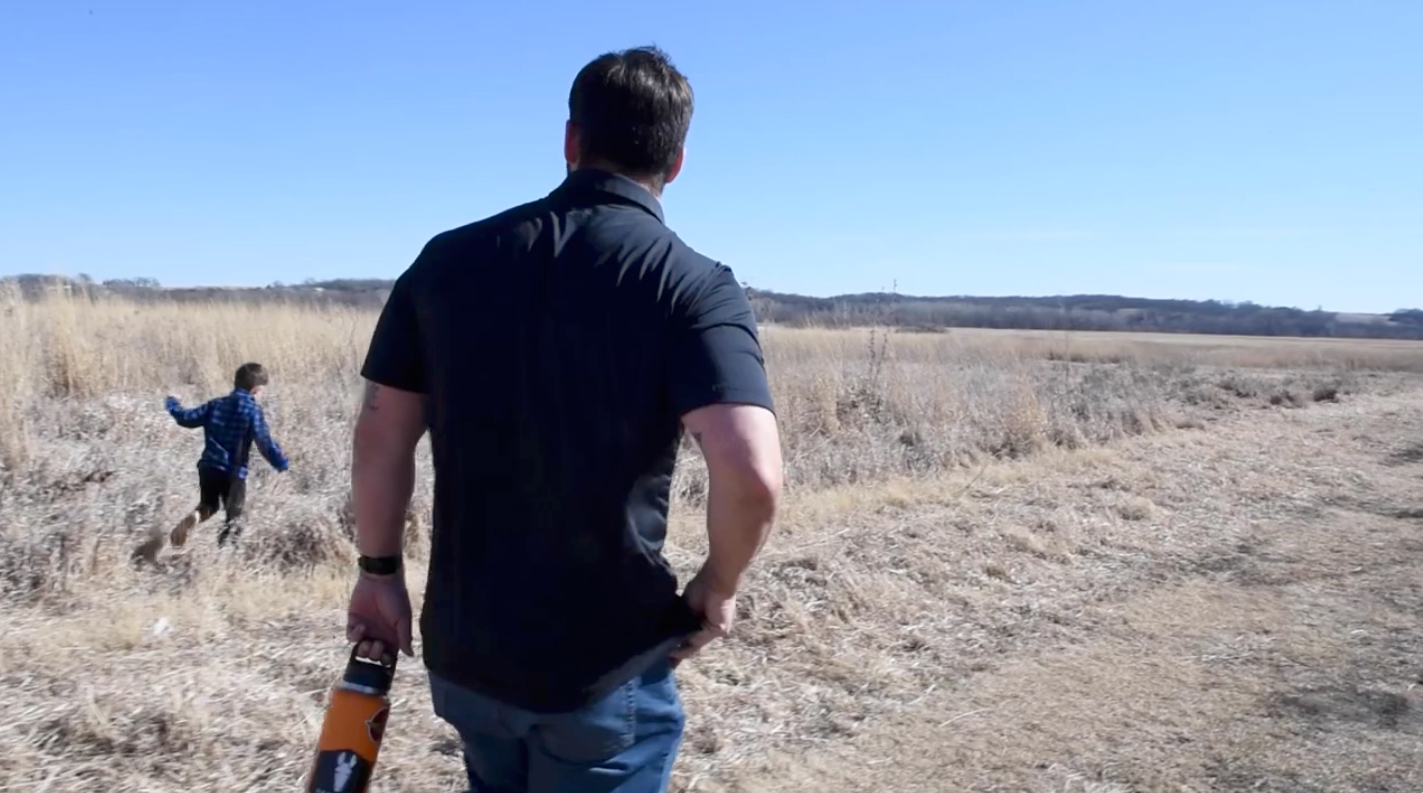 Retired Marine Jacob Ledford walks along a field with his son