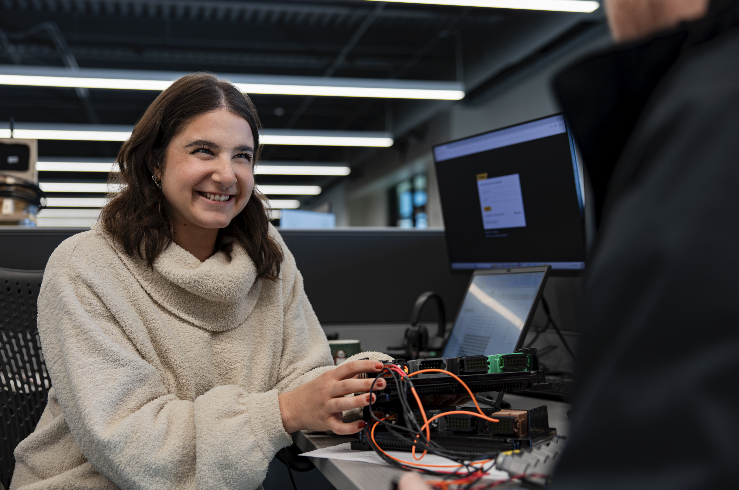 woman at desk wearing a white sweater